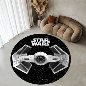 May include: A round black and white rug with a Star Wars TIE fighter spaceship design. The rug features a black background with white stars and the text "STAR WARS" in white letters.