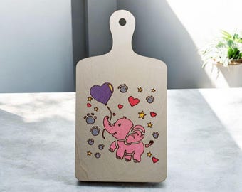 A lovely little elephant playing with a heart balloon on a wooden paddle. Done with pyrography and acrylic pens.