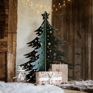 Può includere: Un albero di Natale in metallo nero con una stella in cima, decorato con stelle bianche. L'albero è posizionato davanti a un muro di legno con un'apertura a forma di cuore. Ci sono regali avvolti davanti all'albero.