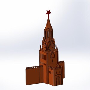 May include: A brown model of a clock tower with a red star on top. The tower has a clock face on each side and a wall surrounding the base.