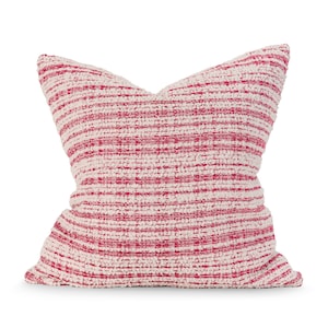 May include: A white and pink striped throw pillow with a soft, textured fabric.