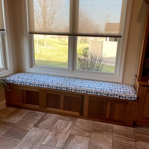 a room with a window seat and a potted plant