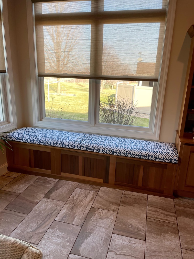 a room with a window seat and a potted plant