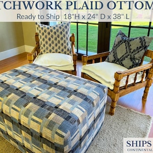 May include: Patchwork plaid ottoman with a blue, gray, and beige geometric pattern. The ottoman is 18 inches high, 24 inches deep, and 38 inches long. Two wooden chairs with patterned pillows and white cushions are in the background.