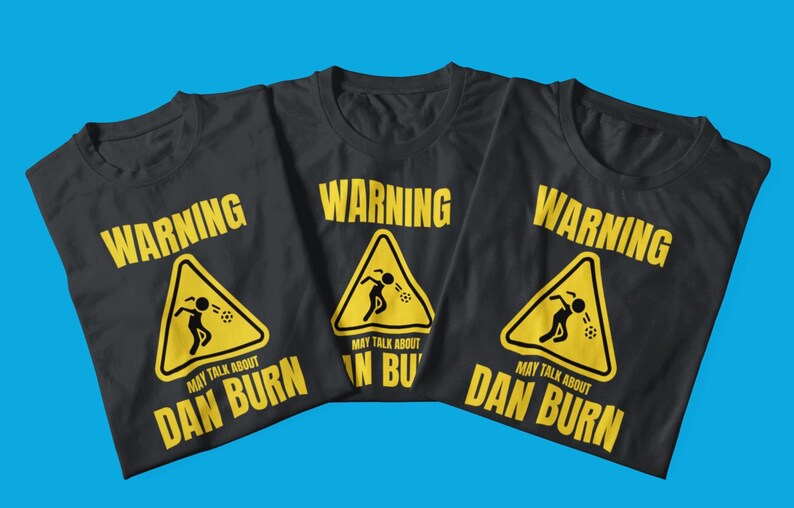 May include: Three black t-shirts with a yellow warning sign graphic. The sign says "Warning May Talk About Dan Burn".