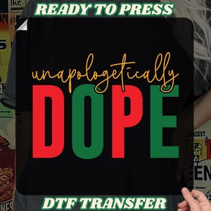 May include: Black DTF transfer with the words "unapologetically DOPE" in red, green, and gold lettering. The words "READY TO PRESS" and "DTF TRANSFER" are in green and white lettering.