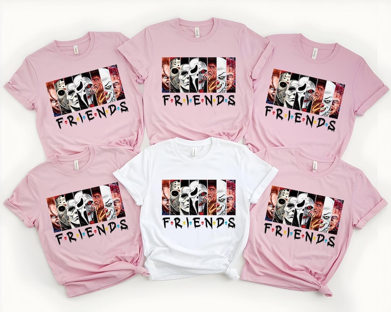 May include: A collection of pink and white t-shirts featuring a graphic design with horror movie characters and the word "FRIENDS" in a stylized font. The shirts are short-sleeved and made of a soft material.