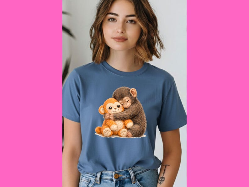 Op de afbeelding: Een blauw t-shirt met een aquarel illustratie van twee knuffelende apen. E&eacute;n aap is bruin, de andere oranje. De apen zitten op een wit oppervlak.
