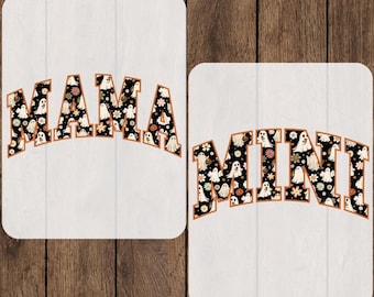 May include: Two DTF transfer sheets featuring the words MAMA and MINI in a bold, arched font. The letters have a black background filled with a repeating pattern of white ghosts, orange pumpkins, and small flowers with a thin orange outline.