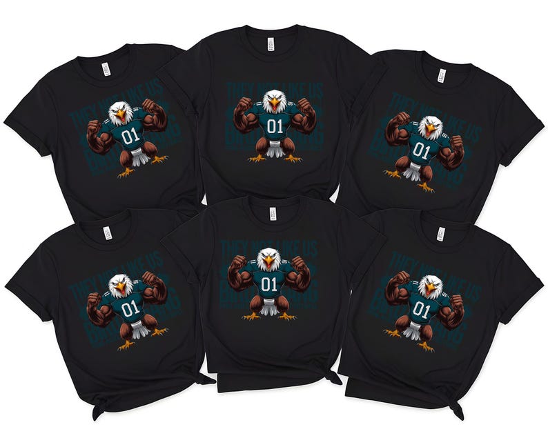 K&ouml;nnte beinhalten: Sechs schwarze T-Shirts mit einem Cartoon-Adler-Design. Der Adler spannt seine Muskeln an und tr&auml;gt ein t&uuml;rkisfarbenes Trikot mit der Nummer 01. Der Adler ist vor einem t&uuml;rkisfarbenen Hintergrund platziert. Die Shirts sind kurz&auml;rmelig.
