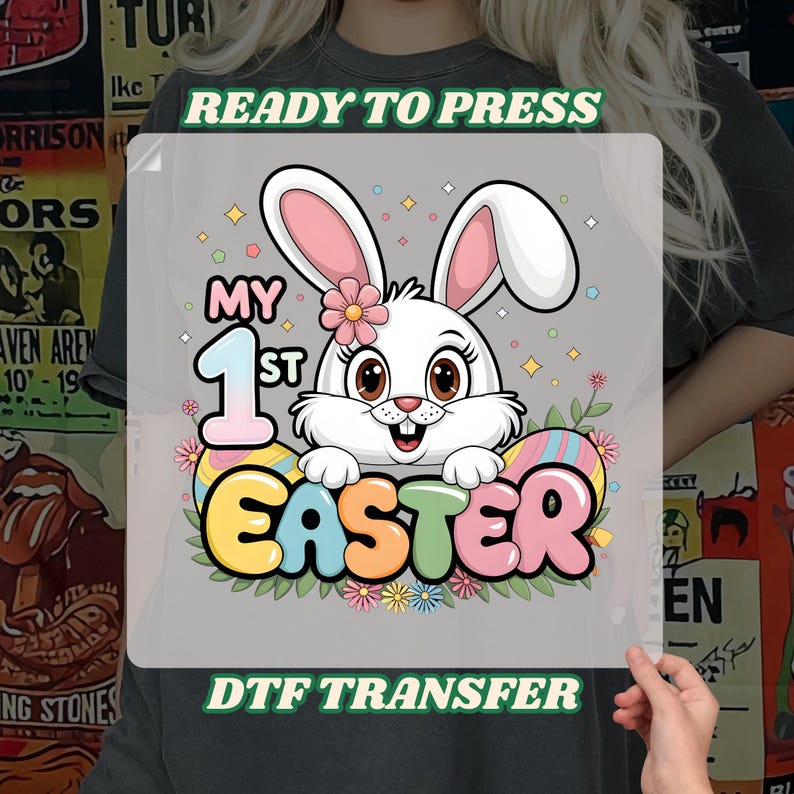 May include: A gray t-shirt with a white bunny rabbit holding a colorful Easter egg that says "My 1st Easter". The text "Ready to Press" and "DTF Transfer" are also on the shirt.