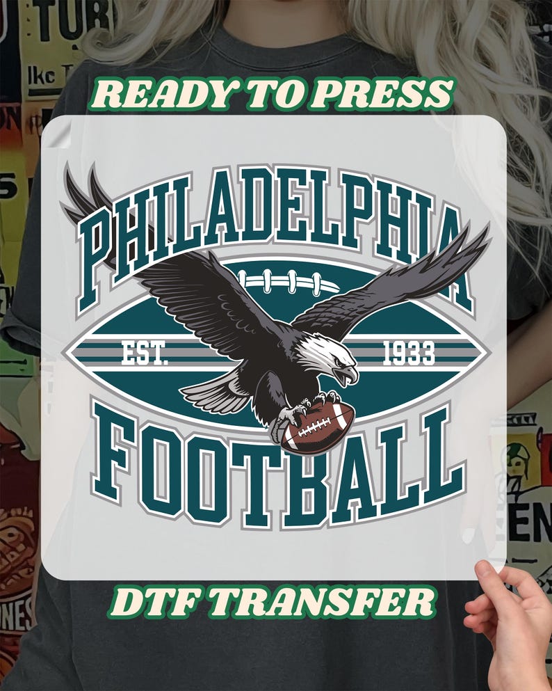 Może przedstawiać: Transfer DTF z napisem "PHILADELPHIA FOOTBALL" i grafiką orła trzymającego piłkę nożną. Projekt zawiera tekst "EST. 1933" oraz "READY TO PRESS" i "DTF TRANSFER" w kolorze zielonym.