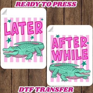 May include: Two DTF transfer designs with a white background, pink stripes, and a teal alligator. One design says "LATER" and the other says "AFTER WHILE" in pink letters. Green stars are scattered around the text and alligator.
