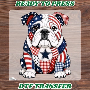 May include: A DTF transfer featuring a patriotic bulldog design. The bulldog is depicted in red, white, and blue patterns, including stars and stripes. The words "READY TO PRESS" and "DTF TRANSFER" are printed on the image.