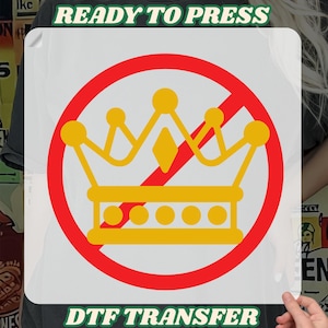 May include: A white DTF transfer with a yellow crown inside a red circle with a red slash through it. The words "READY TO PRESS" and "DTF TRANSFER" are printed in green.