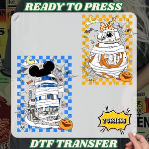 May include: Two DTF transfer designs featuring cartoon characters in Halloween costumes. One design shows a character wrapped in bandages, and the other shows a character with a bow. The text "READY TO PRESS" and "DTF TRANSFER" are visible.