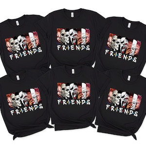 May include: Six black t-shirts with a graphic featuring horror movie characters and the word "FRIENDS" in white. The graphic includes faces of iconic horror characters. The shirts are short-sleeved.