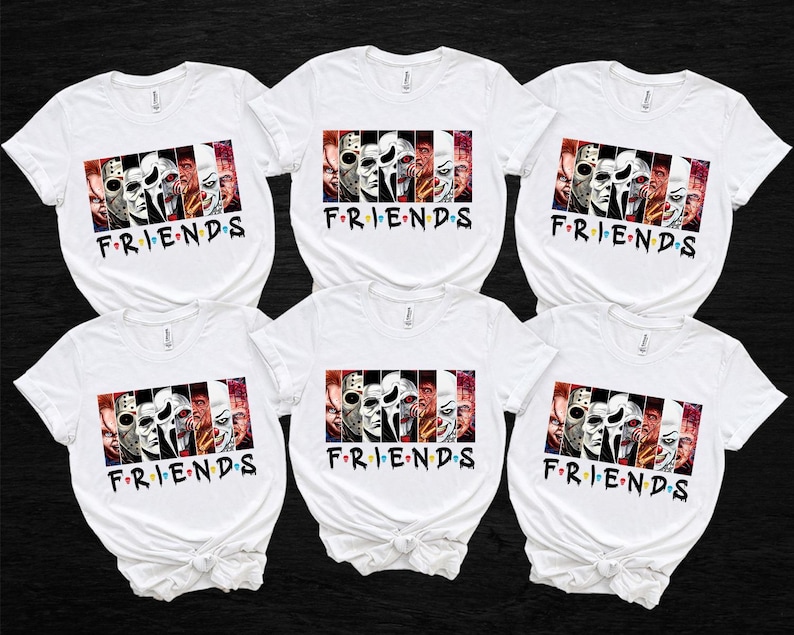 May include: White t-shirts with a graphic featuring horror movie characters and the word "FRIENDS" in a colorful font. The graphic is a collage of iconic horror movie villains. The shirts are arranged on a black background.