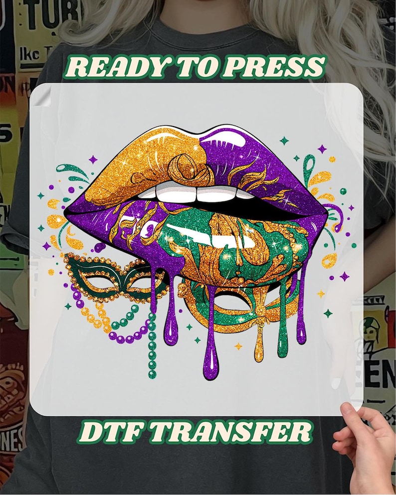 May include: DTF transfer featuring a vibrant design of lips in gold, purple, and green, with a dripping effect. A masquerade mask and beaded necklace are also included in the design. The text "READY TO PRESS" and "DTF TRANSFER" are displayed.
