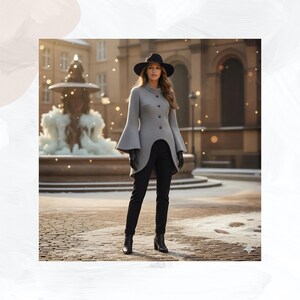 May include: A light gray long-sleeved coat with a high collar, button-down front, and flared bell sleeves. The coat features a curved hemline that is shorter in the front and longer in the back, paired with black trousers, black gloves, and a black hat.