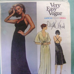 May include: A sewing pattern featuring three different dress designs. The pattern is for a long, flowing gown with a plunging neckline, a long gown with a tie at the waist, and a shorter gown with a halter neckline. The pattern is by Edith Head, a legendary costume designer. The text "Very Easy Vogue" is printed on the pattern.