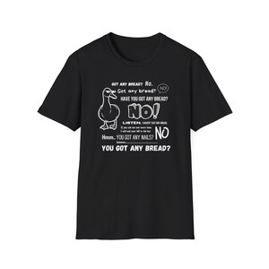 Könnte beinhalten: Schwarzes T-Shirt mit einer weißen Grafik einer Ente und humorvollem Text. Der Text enthält Sätze wie "Got any bread?" und "You got any nails?" in einem Sprechblasendesign.