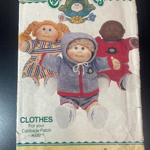 May include: Vintage Butterick sewing pattern for Cabbage Patch Kids clothes. The cover features three Cabbage Patch Kids dolls wearing different outfits. The text on the cover reads "CLOTHES For your Cabbage Patch Kids!" and "BUTTERICK".