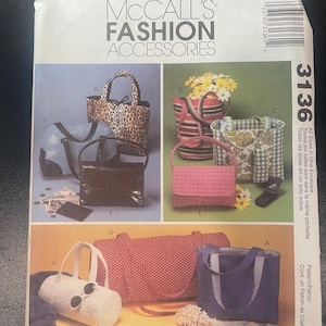 May include: A McCall's Fashion Accessories sewing pattern envelope, number 3136, featuring illustrations of various bags including totes, duffels, and handbags in leopard print, plaid, polka dot, and solid fabrics with assorted handle styles.