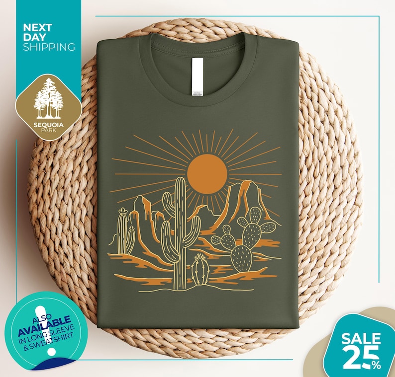 a green t-shirt with a desert landscape design, including cacti and mountains, along with a sun illustration. The t-shirt is displayed on a woven basket, and there are various texts and logos surrounding the image.