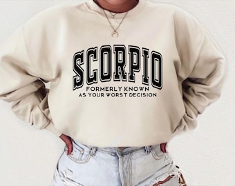 Può includere: Una felpa beige con testo nero che recita "Scorpio Formerly Known As Your Worst Decision".