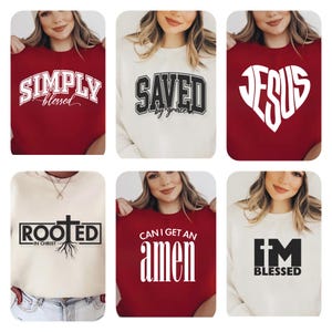 Puede incluir: Seis diseños diferentes de sudaderas con texto de temática cristiana. Las sudaderas son de color rojo y crema. El texto incluye "Simply Blessed", "Saved by Grace", "Jesus", "Rooted in Christ", "Can I Get an Amen", y "I'm Blessed".