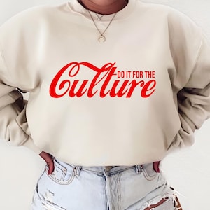 May include: A cream coloured sweatshirt with a red Coca-Cola inspired graphic that says "Do it for the Culture".