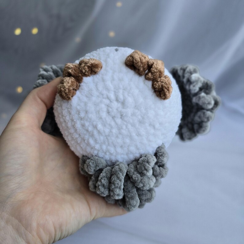 Pu&ograve; includere: Un giocattolo a forma di gufo di peluche fatto a mano. Il gufo ha un corpo bianco con zampe e dettagli marroni, e ali e piume della coda grigie. Il giocattolo &egrave; realizzato in materiale morbido e strutturato ed &egrave; progettato per essere coccolato.