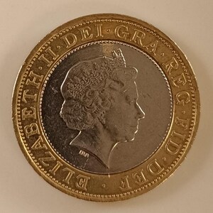 Puede incluir: Una moneda de dos libras esterlinas con un perfil de la reina Isabel II, con la inscripción "ELIZABETH II DEI GRA REG FID DEF". La moneda tiene un anillo exterior dorado y un centro plateado. El diámetro es de aproximadamente 2,8 cm.