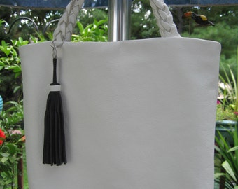 White leather tote 12" X 11" X 5 1/2" handle drop 2 1/2" bottom width..black 5" tassel..Sam is beautiful...