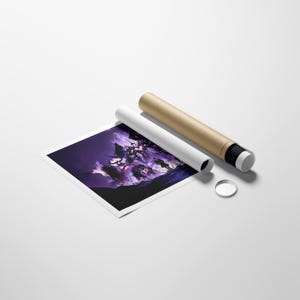 May include: A rolled art print featuring a dark purple and black landscape, alongside a rolled brown tube and a small, clear, circular object. The print rests on a white surface.