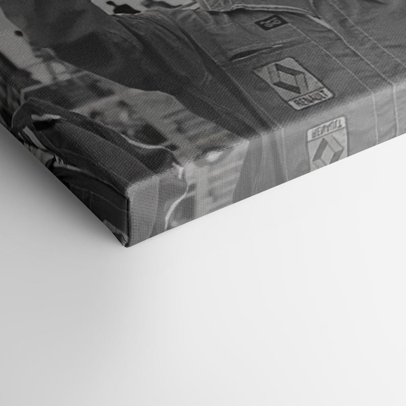 May include: Monochrome canvas print of a racing suit. The suit displays the Renault logo and various patches. The image is a close-up, highlighting the suit's texture and design details.