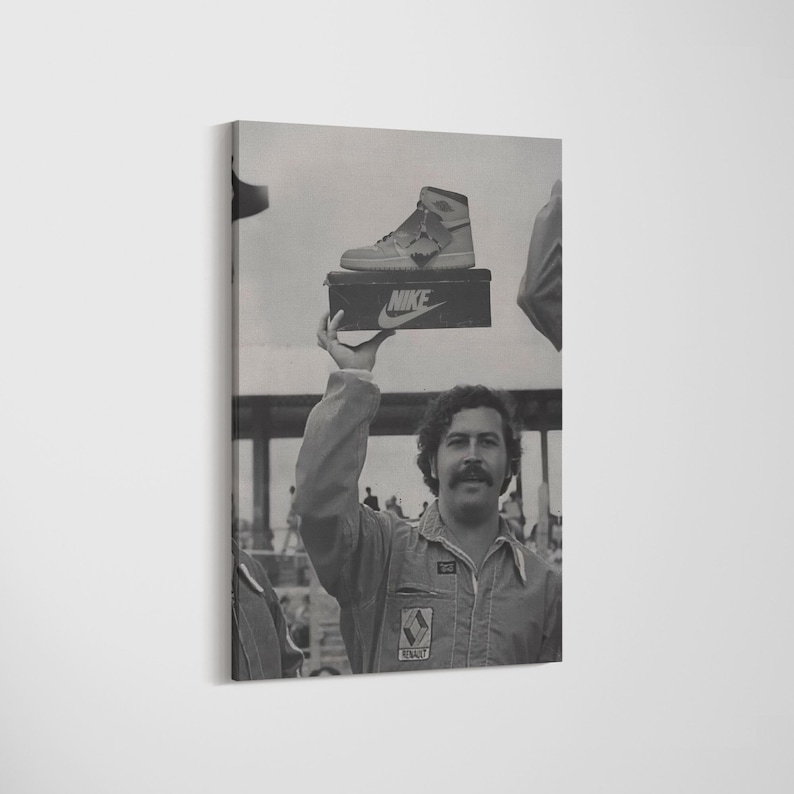 May include: Monochrome canvas print showing a man holding a Nike shoebox with a high-top trainer. The man wears a jumpsuit and has a moustache. The Nike logo is visible on the shoebox.