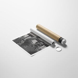 May include: Monochrome print of a man with a moustache in a button-up shirt, alongside a poster tube. The print is partially unrolled, revealing the image. A white rolled poster and a clear disc are also present.
