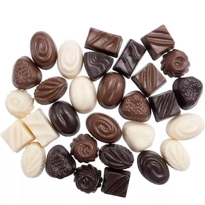 Pode incluir: Um sortimento de chocolates variados em uma variedade de formas e tamanhos. Os chocolates estão dispostos em um círculo sobre um fundo branco. Os chocolates são uma mistura de chocolate preto, ao leite e branco.