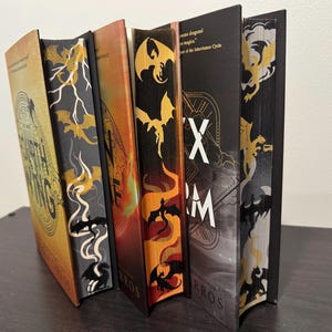 May include: A set of four fantasy novels with dragon illustrations on the covers. The books are titled "Eragon", "Eldest", "Brisingr", and "Inheritance".