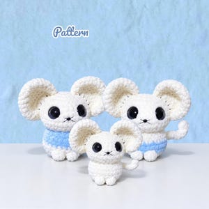 May include: Three white crocheted mouse plush toys with large ears, black plastic eyes, and light blue textured bellies. The word Pattern is printed in white text above the toys. Each mouse has a small tail and sits in an upright position.