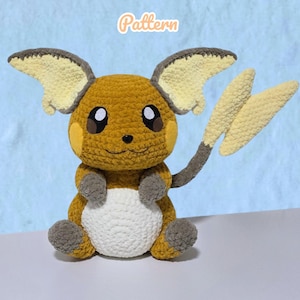 Puede incluir: Un peluche de ganchillo marrón y blanco con grandes orejas puntiagudas con secciones interiores de color amarillo pálido, una barriga blanca y una cola en forma de rayo. La palabra Pattern está impresa en naranja sobre la cabeza.