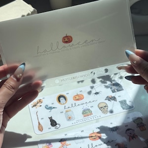 May include: Clear plastic sleeve containing Halloween-themed stickers. The sleeve has the word "halloween" and a pumpkin graphic. The stickers feature various Halloween images, including pumpkins, ghosts, and bats. The text "HUSTLE&FLOWSCO" is also visible.