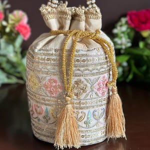 AEVA - Ivory White Potli Bag with Fine Pastel Embroidery and Ethnic Lacework for Indian Weddings and Anniversary Functions .
