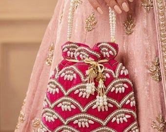 Bolso de mano NILAM color rosa fucsia con flecos de perlas blancas, ideal para fiestas culturales reales y eventos en galerías de arte.