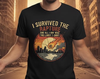 May include: Black t-shirt with a distressed graphic featuring the text "I Survived The Rapture" above a circular design of a meteor, cityscape, and a t-shirt. The design has orange, yellow, and gray tones.