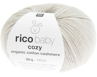 May include: A ball of light gray yarn with a label that reads "rico baby cozy organic cotton cashmere." The label features a cartoon bunny and the text "50g ~ 145 m."