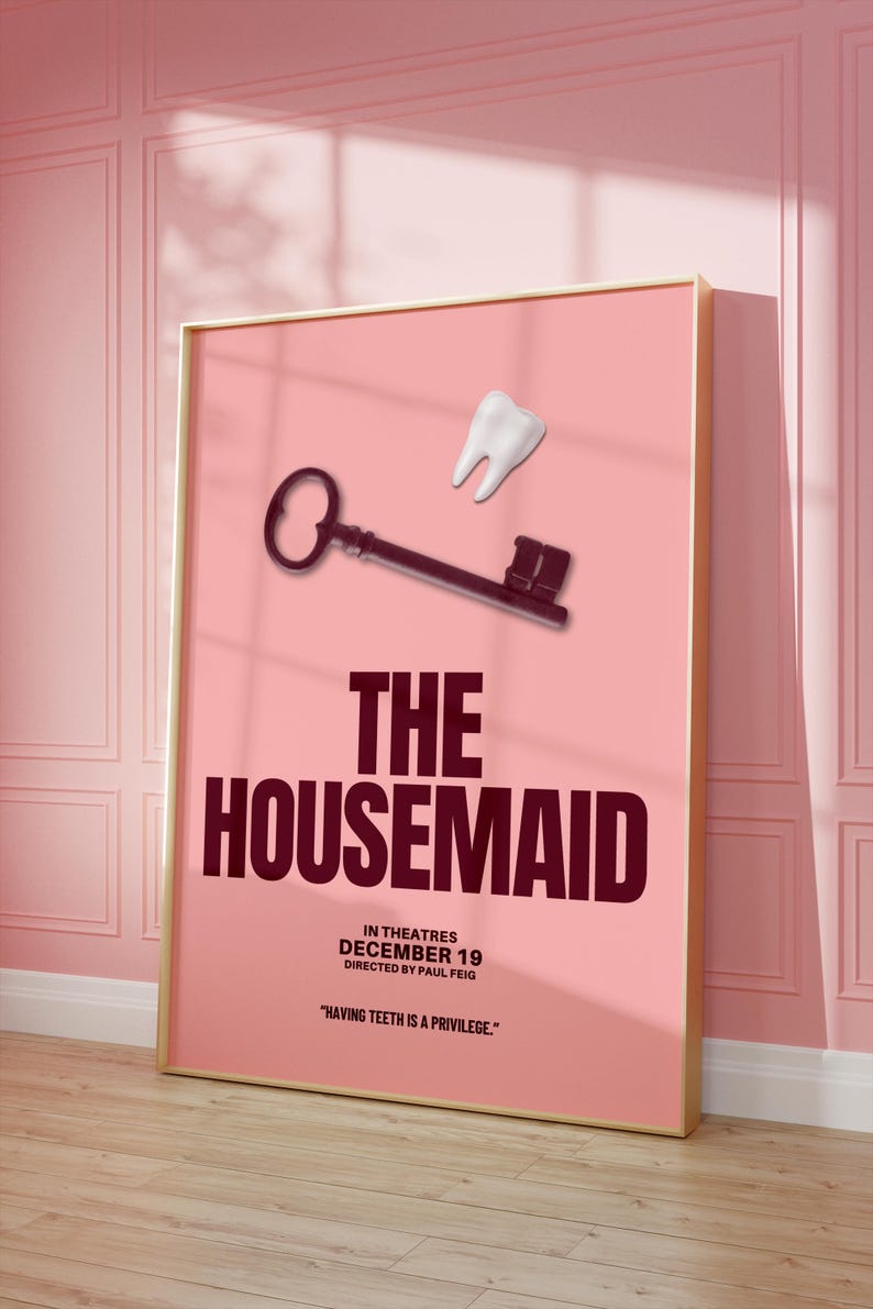 May include: A framed movie poster for "The Housemaid" with a pink background. The poster features a key and a tooth graphic. The movie title is in large, dark red letters. The release date is December 19.