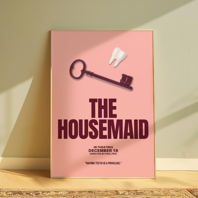 May include: A framed poster with a pink background. It features a key and a tooth graphic. The title "THE HOUSEMAID" is in large maroon letters. Additional text includes "IN THEATRES DECEMBER 19" and a quote: "HAVING TEETH IS A PRIVILEGE."